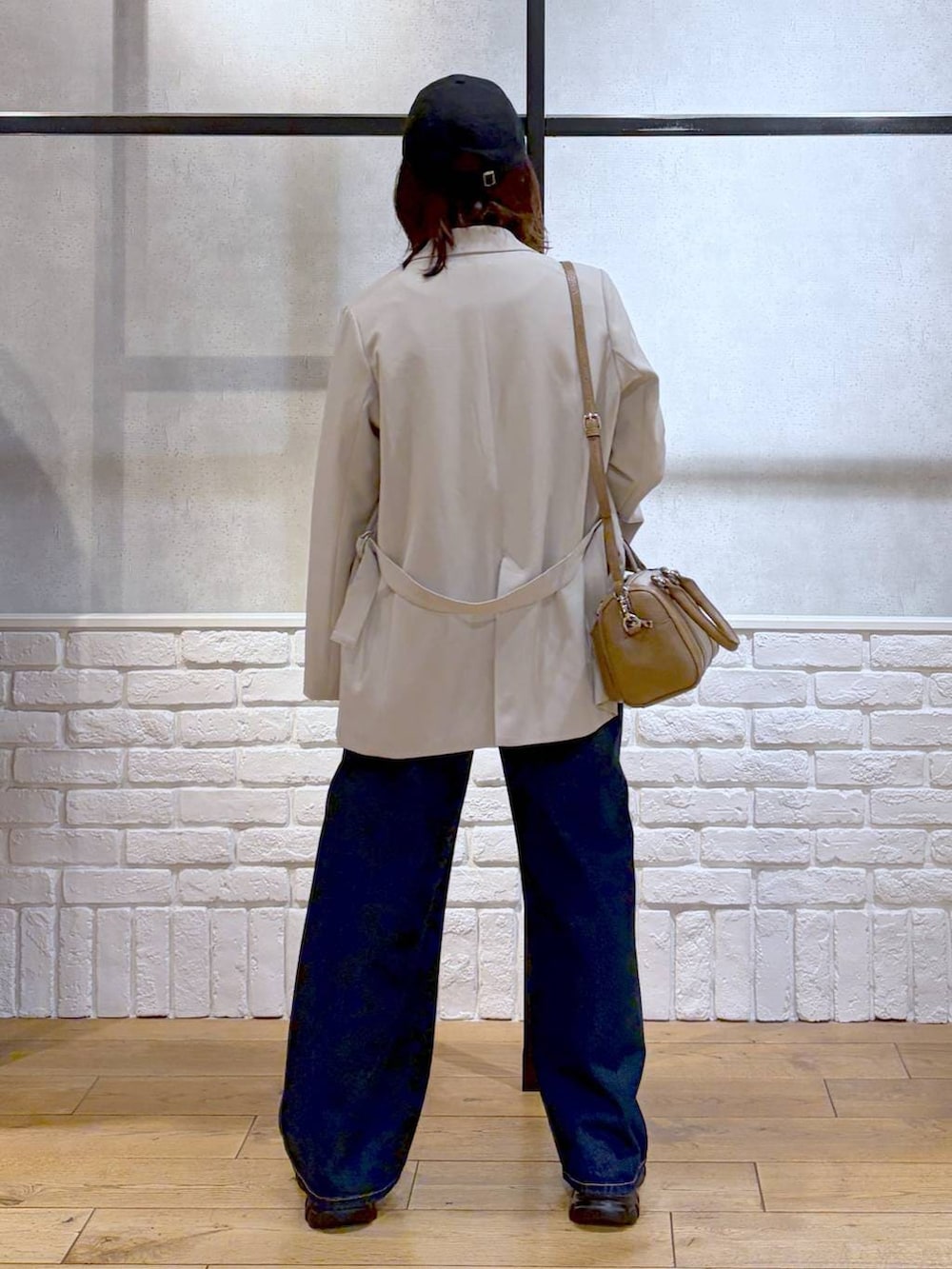 ブラック系のローファー、ブルー系のスラックス、ブラウン系のボストンバッグを着用したレディースの冬コーディネートの8枚目の写真