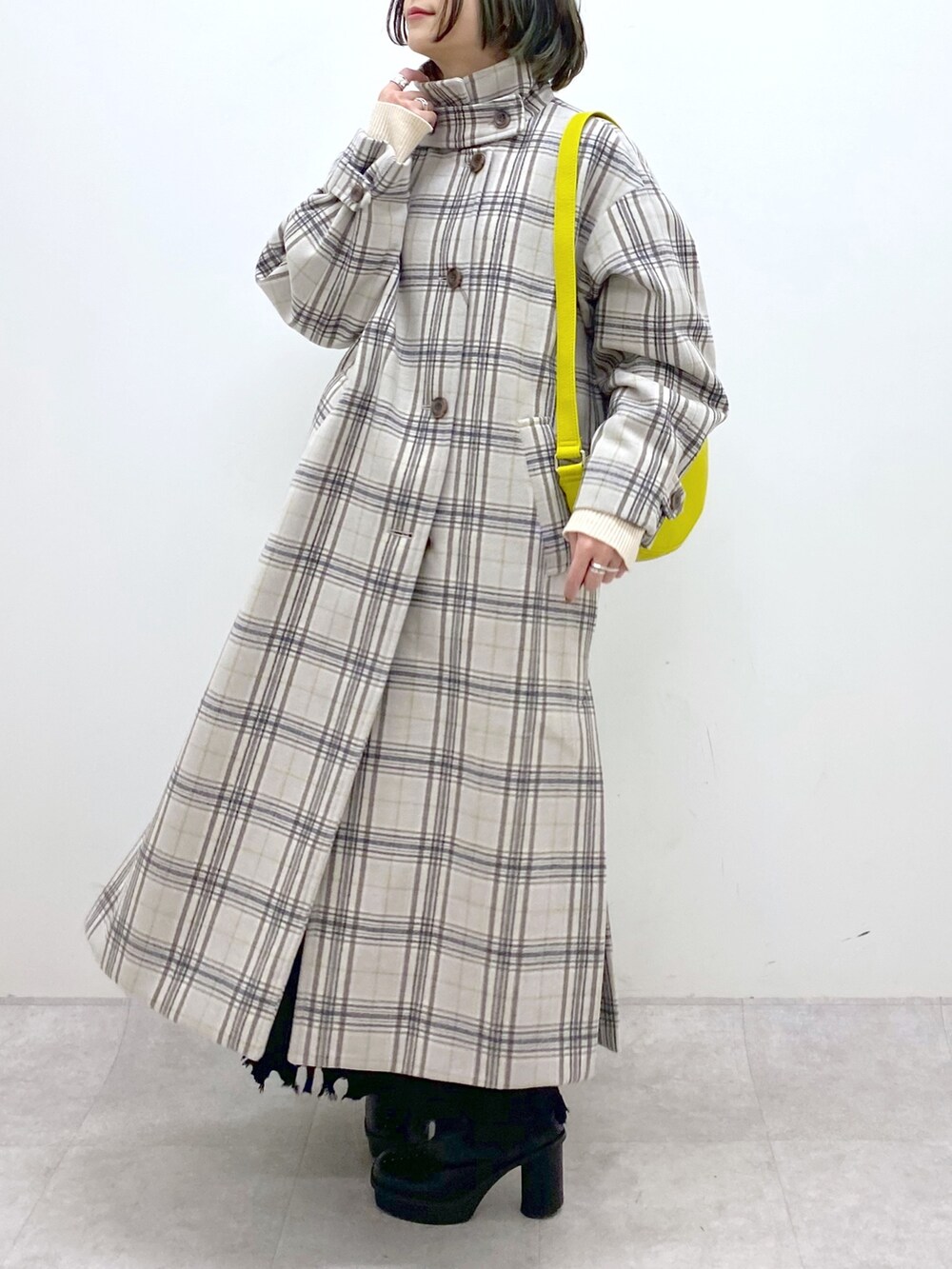 ホワイト系のジャケット/アウター、ブラック系のブーツ、ブラック系のスカートを着用したレディースの冬コーディネートの4枚目の写真