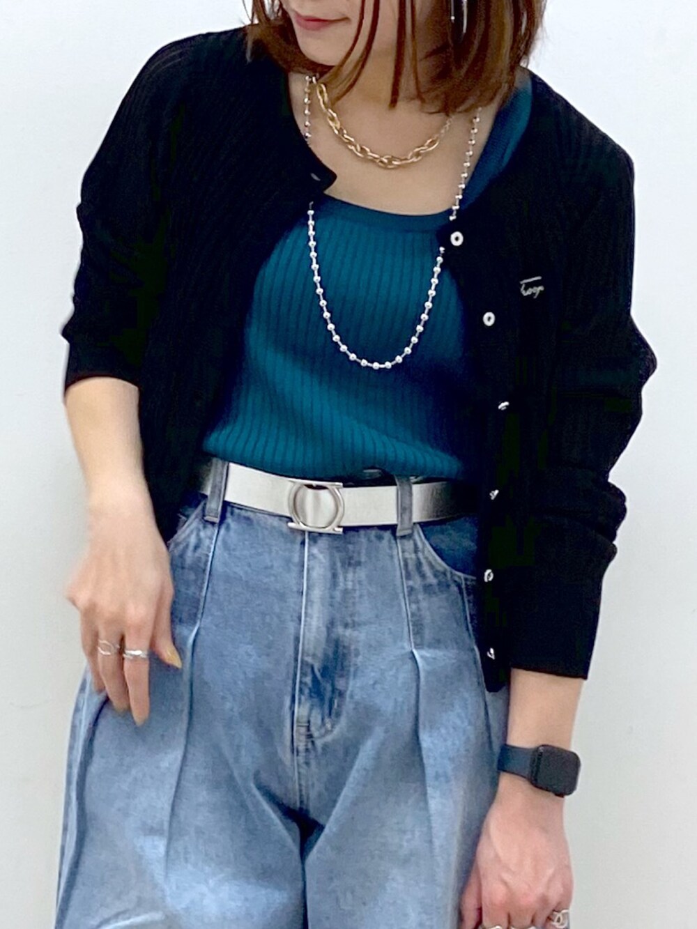 ブラック系のカーディガン/ボレロ、グリーン系のタンクトップ、ブルー系のデニムパンツを着用したレディースの春コーディネートの2枚目の写真