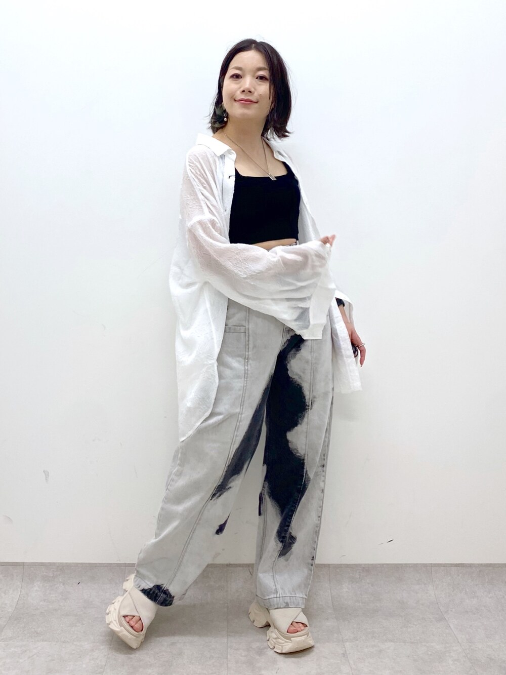 ホワイト系のサンダル、ブラック系のデニムパンツ、ブラック系のタンクトップを着用したレディースの夏コーディネートの9枚目の写真
