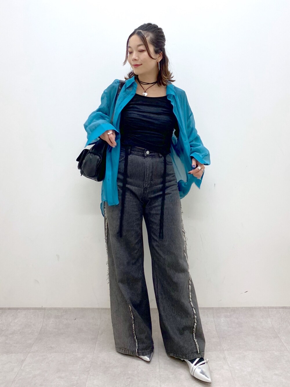 シルバー系のパンプス、ブラック系のデニムパンツ、ブラック系のショルダーバッグを着用したレディースの夏コーディネートの9枚目の写真