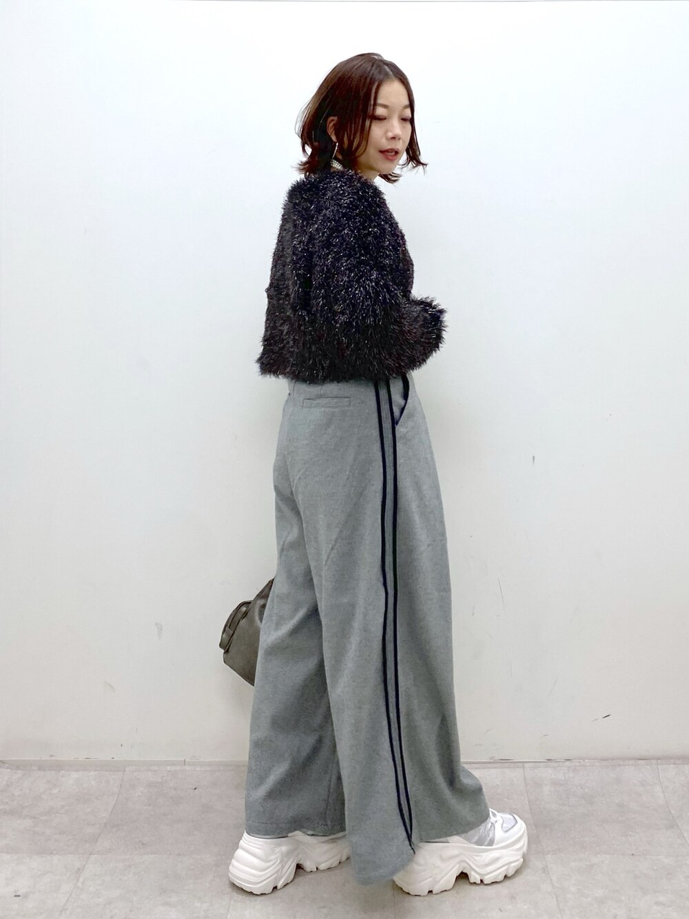 ブラック系のニット/セーター、ブラック系のスラックス、その他のショルダーバッグを着用したレディースの冬コーディネートの7枚目の写真