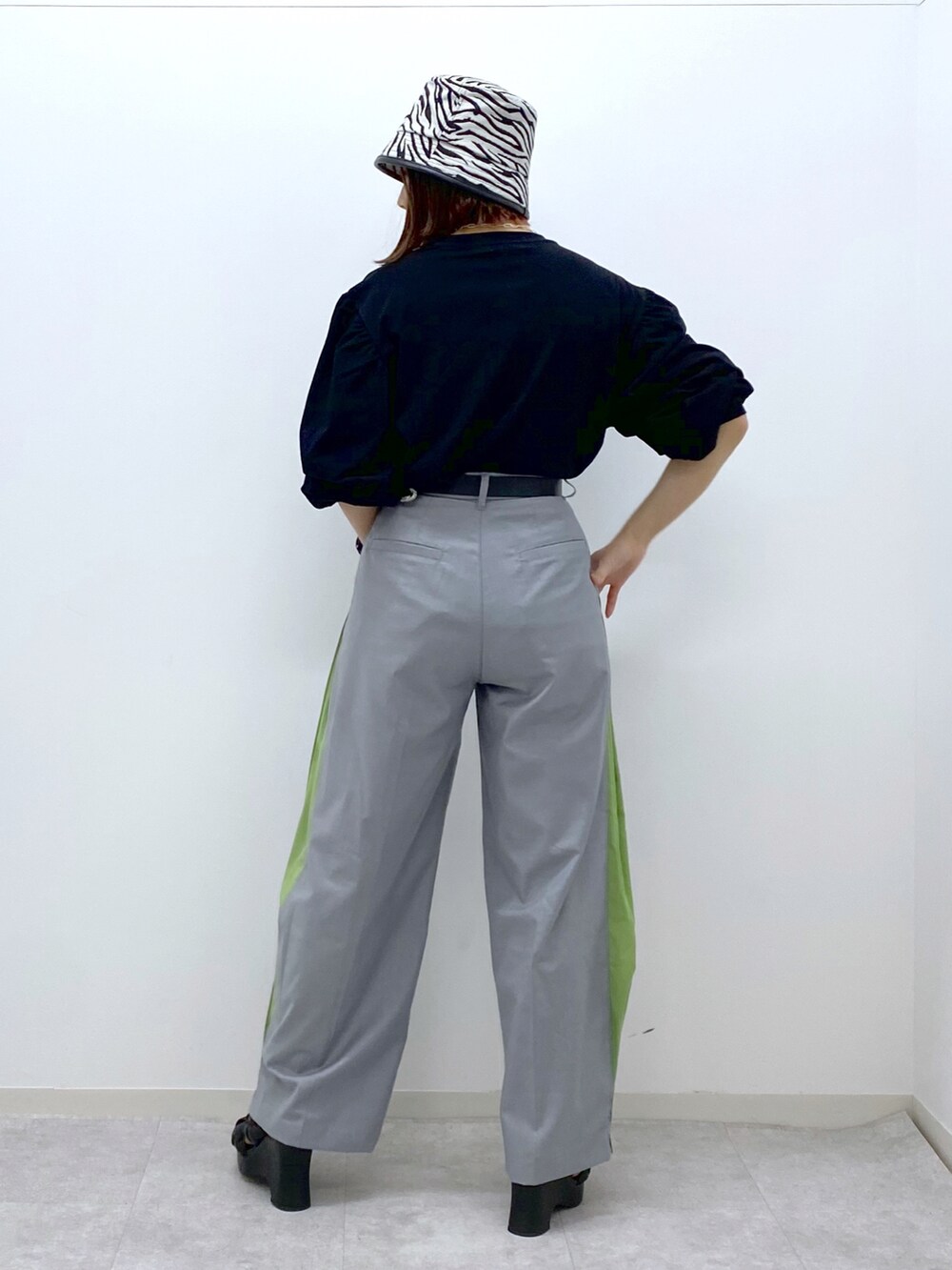 ブラック系のTシャツ/カットソー、グレー系のスラックス、ブラック系のサンダルを着用したレディースの春コーディネートの4枚目の写真