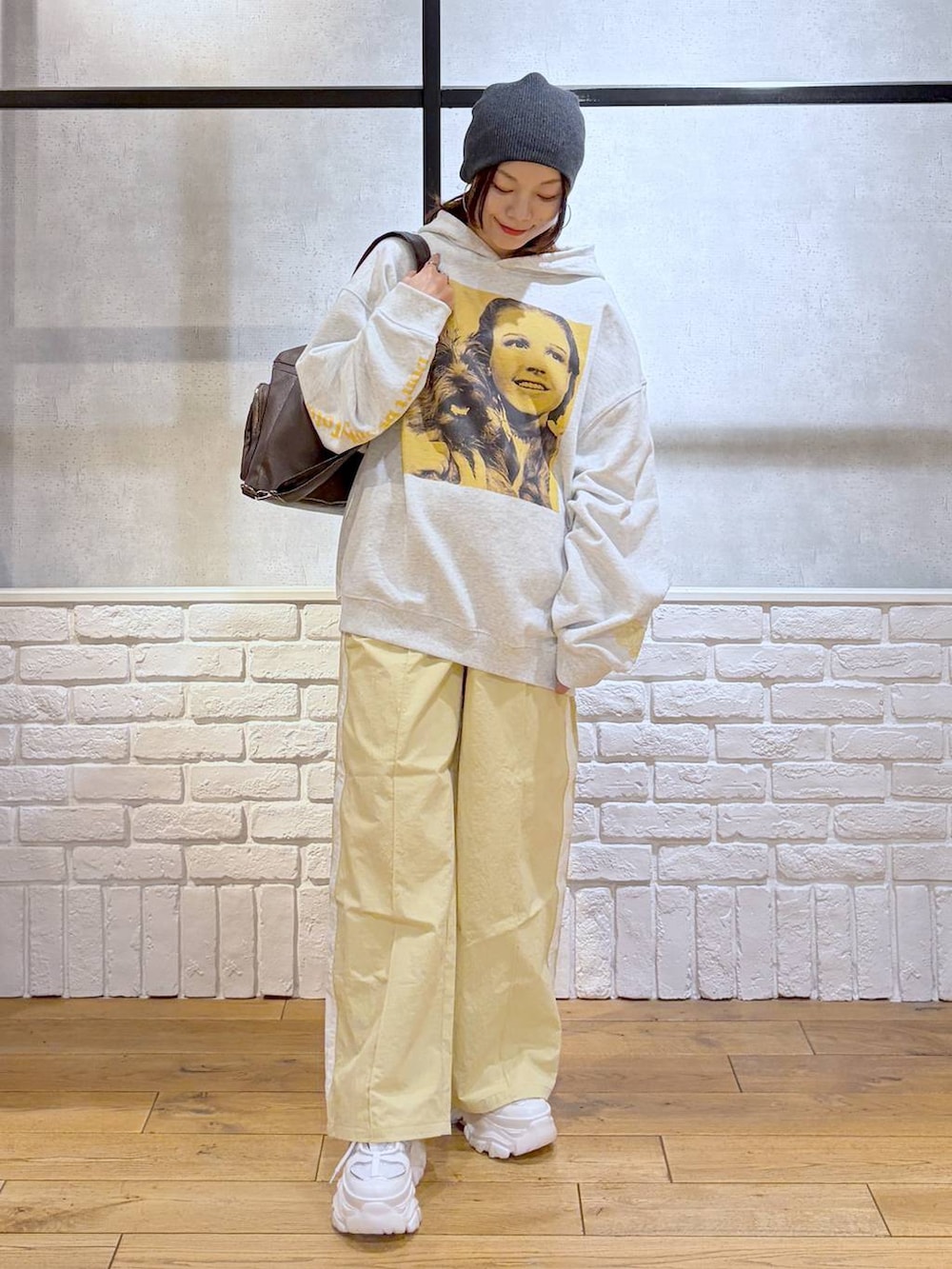 ホワイト系のスニーカー、イエロー系のスウェットパンツ、ブラウン系のショルダーバッグを着用したレディースの春コーディネートの9枚目の写真