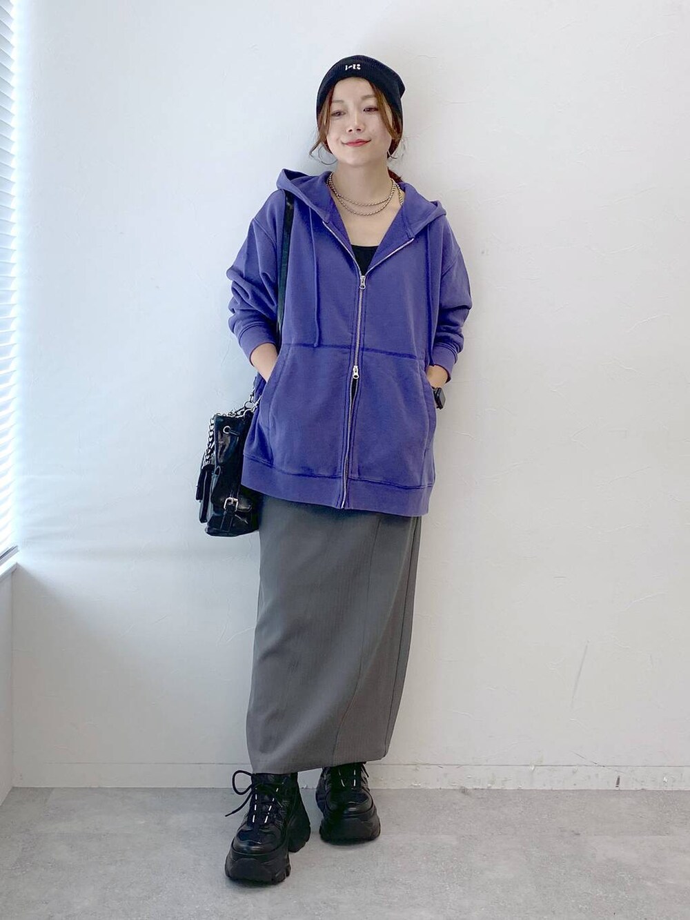 ブラック系のスニーカー、グレー系のスカート、ブラック系のショルダーバッグを着用したレディースの秋コーディネートの9枚目の写真