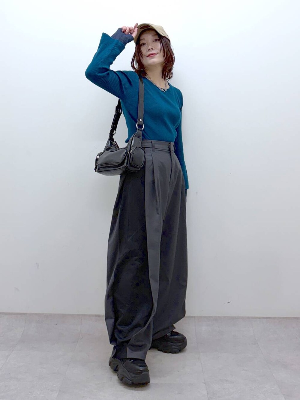 ブラック系のブーツ、グリーン系のニット/セーター、ブラック系のショルダーバッグを着用したレディースの冬コーディネートの9枚目の写真