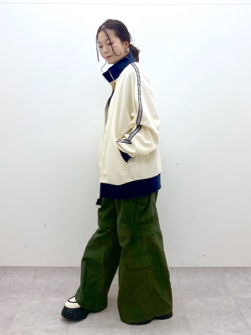 ブラック系のキャミソール、ホワイト系のセットアップ、グリーン系のカーゴパンツを着用したレディースの冬コーディネートの4枚目の写真