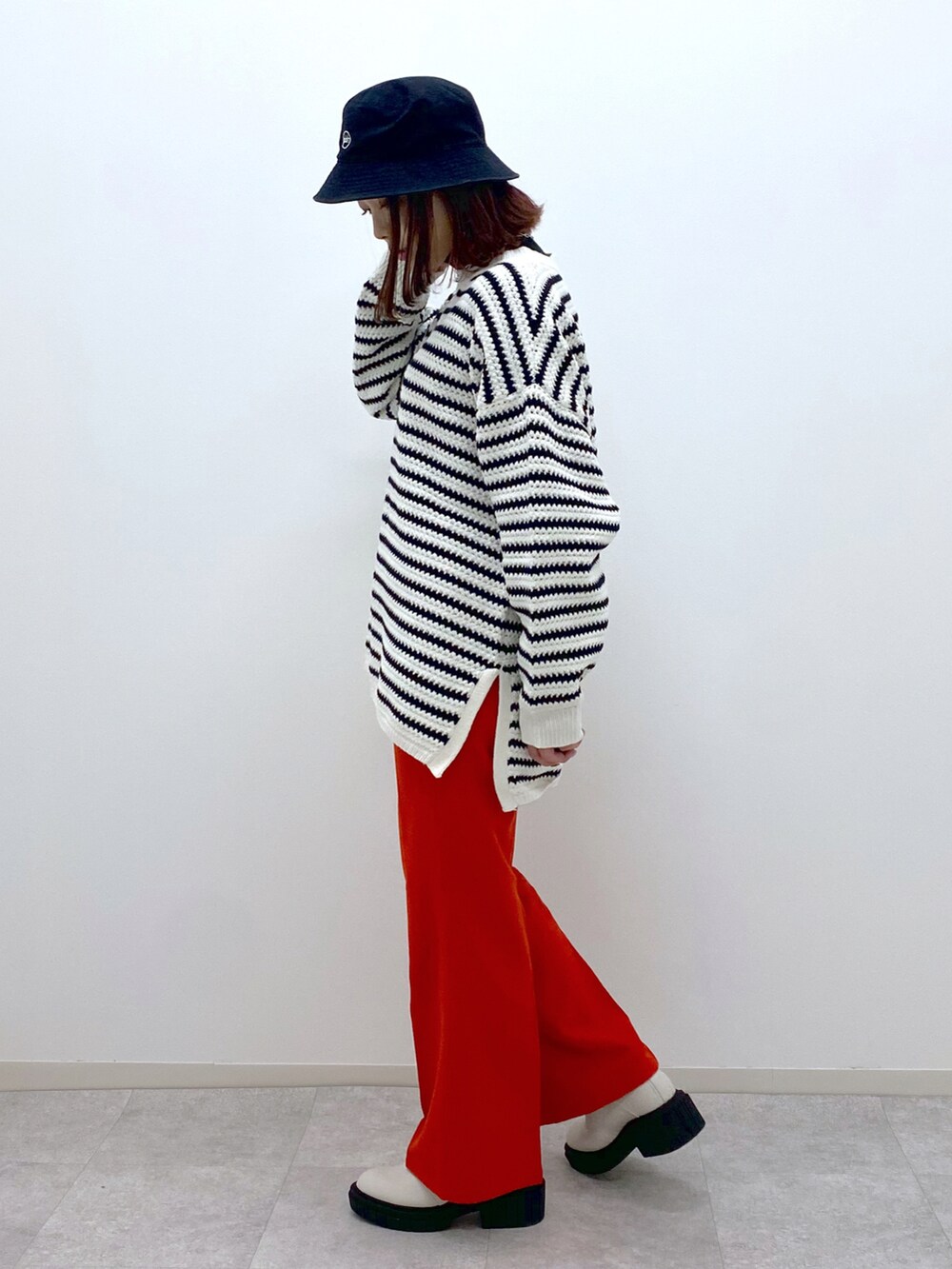 ホワイト系のニット/セーター、レッド系のスラックス、ホワイト系のローファーを着用したレディースの冬コーディネートの3枚目の写真