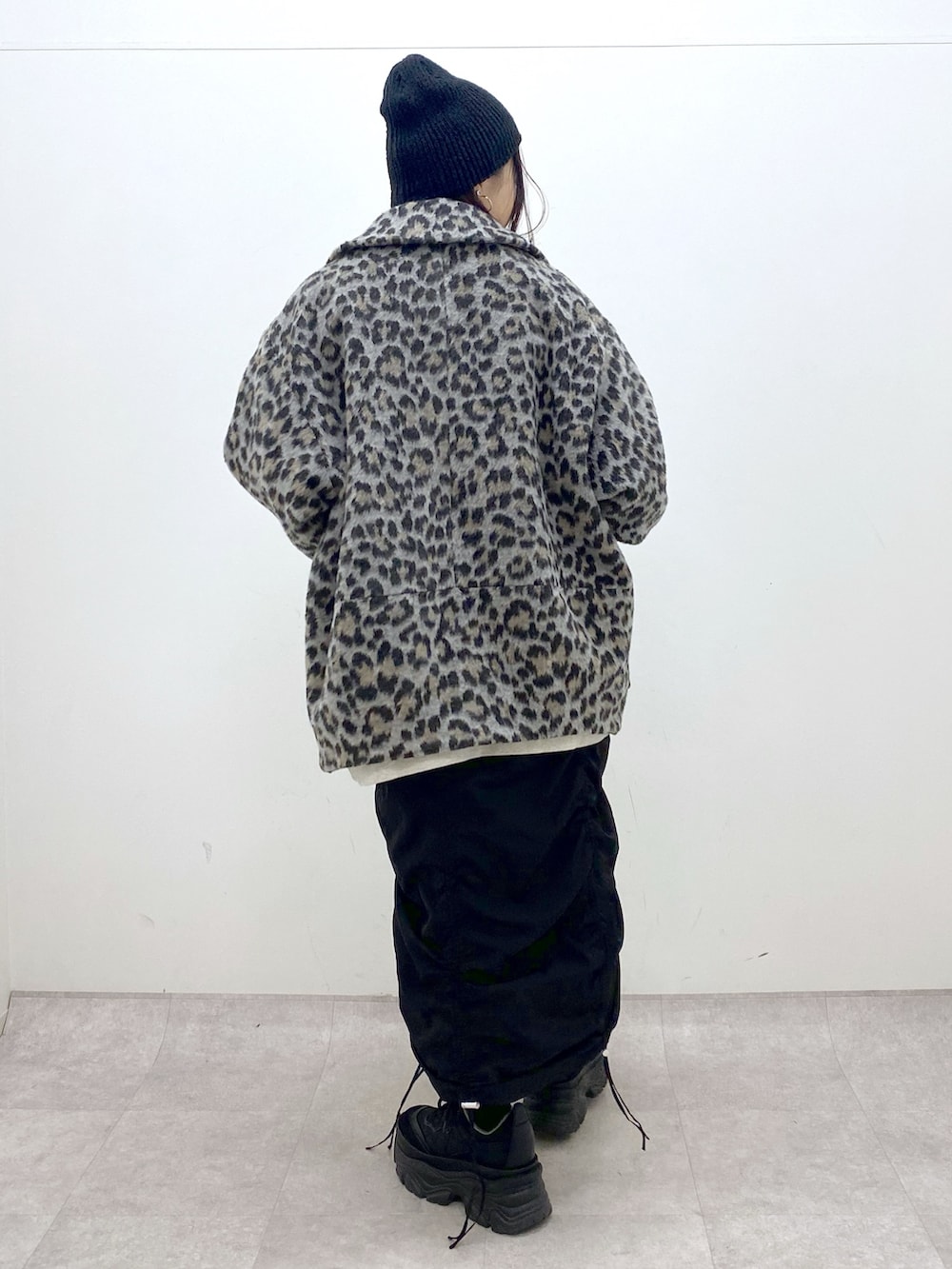 ベージュ系のスウェット、ブラック系のワンピース、ブラック系のスニーカーを着用したレディースの冬コーディネートの4枚目の写真