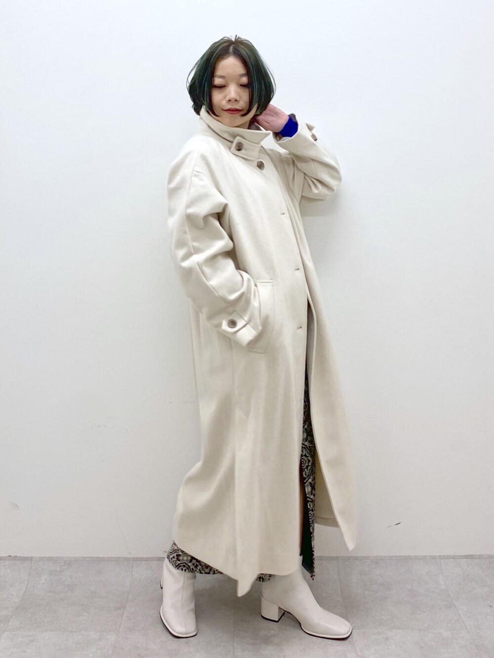 ブルー系のトップス、ホワイト系のジャケット/アウター、ブラック系のスカートを着用したレディースの秋コーディネートの2枚目の写真