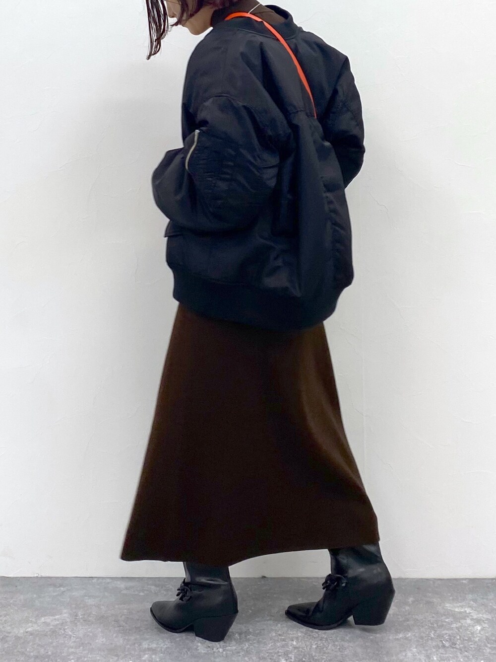 ブラウン系のワンピース、オレンジ系のショルダーバッグ、シルバー系のネックレスを着用したレディースの夏コーディネートの5枚目の写真