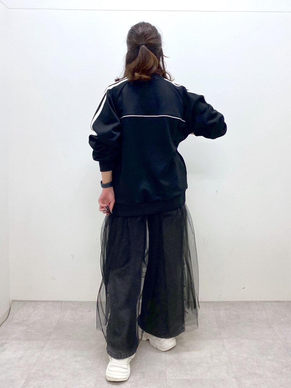 ブラック系のデニムパンツ、ホワイト系のスニーカー、ブラック系のジャージを着用したレディースの夏コーディネートの7枚目の写真