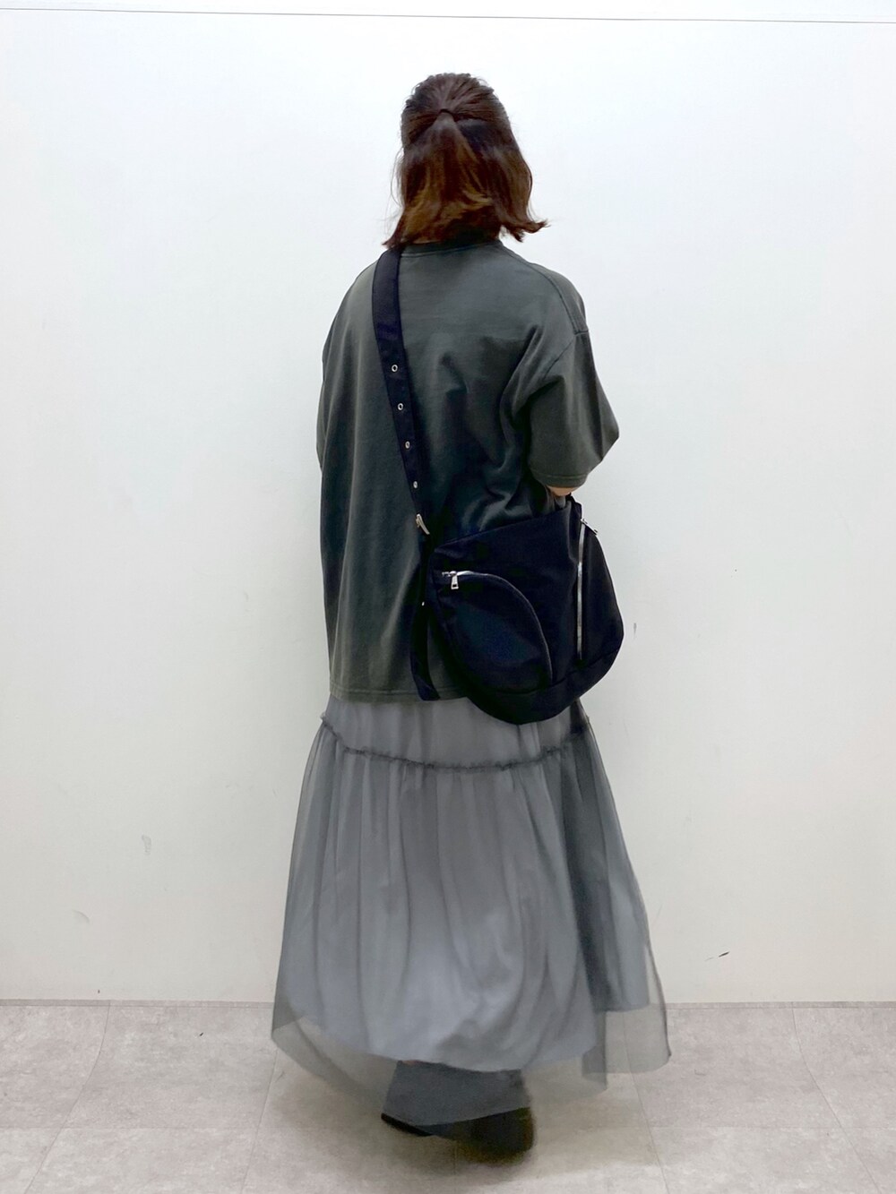 グレー系のTシャツ/カットソー、グレー系のスカート、ブラック系のスニーカーを着用したレディースの夏コーディネートの4枚目の写真