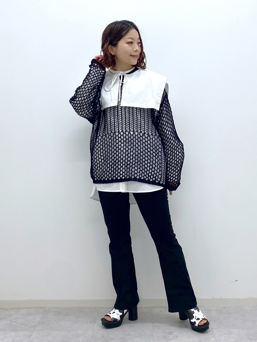 ブラック系のデニムパンツ、ホワイト系のサンダル、ホワイト系のシャツ/ブラウスを着用したレディースの春コーディネートの3枚目の写真