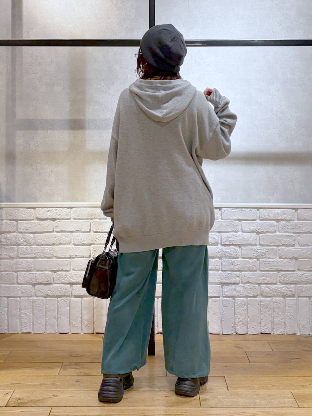 グレー系のスニーカー、グレー系のパーカー、ブラック系のショルダーバッグを着用したレディースの春コーディネートの6枚目の写真