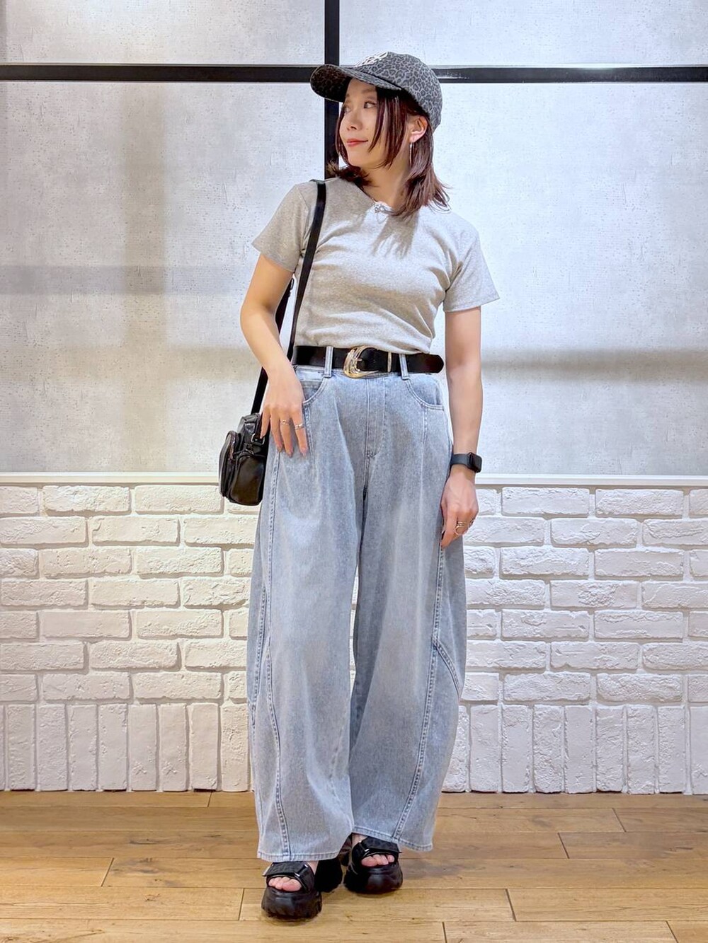 ブルー系のデニムパンツ、ブラック系のショルダーバッグ、ブラック系のサンダルを着用したレディースの春コーディネートの4枚目の写真