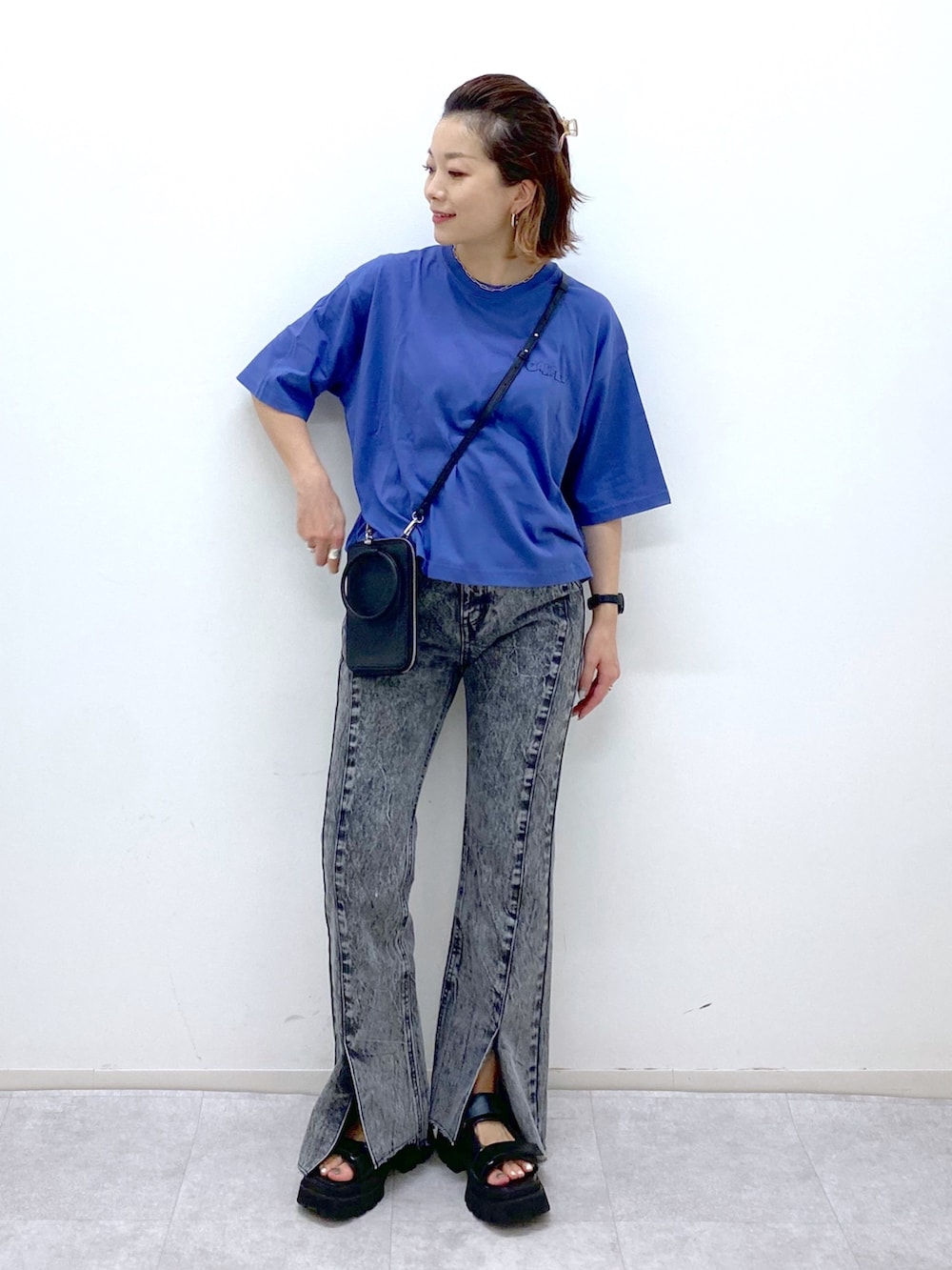 ブラック系のショルダーバッグ、ブラック系のサンダル、ブラック系のデニムパンツを着用したレディースの夏コーディネートの2枚目の写真