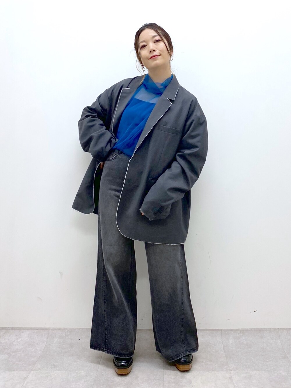 グレー系のテーラードジャケット、ブルー系のシャツ/ブラウス、ブラック系のデニムパンツを着用したレディースの秋コーディネートの9枚目の写真