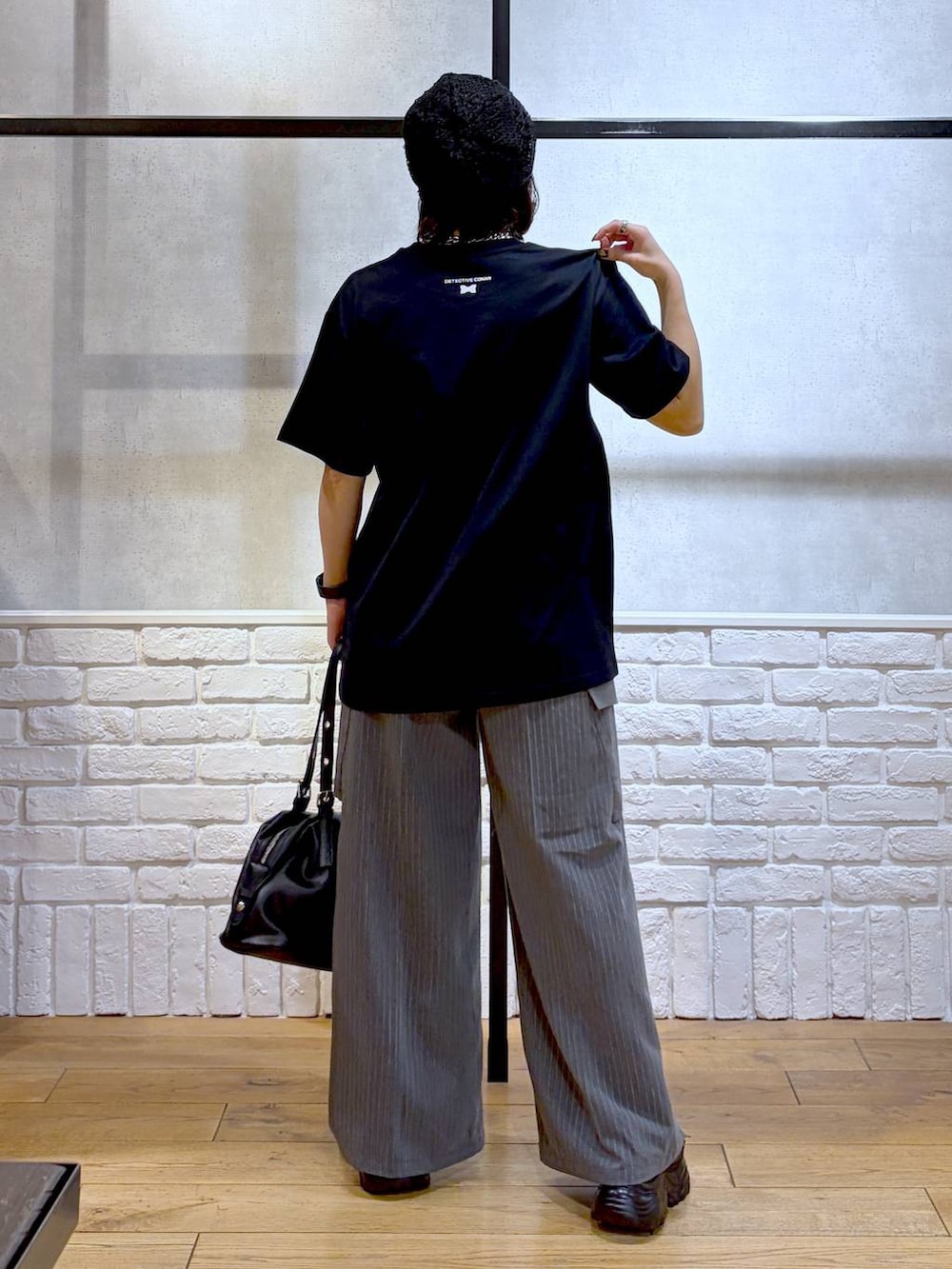 ブラック系のサンダル、ブラック系のボストンバッグ、ブラック系のTシャツ/カットソーを着用したレディースの春コーディネートの6枚目の写真
