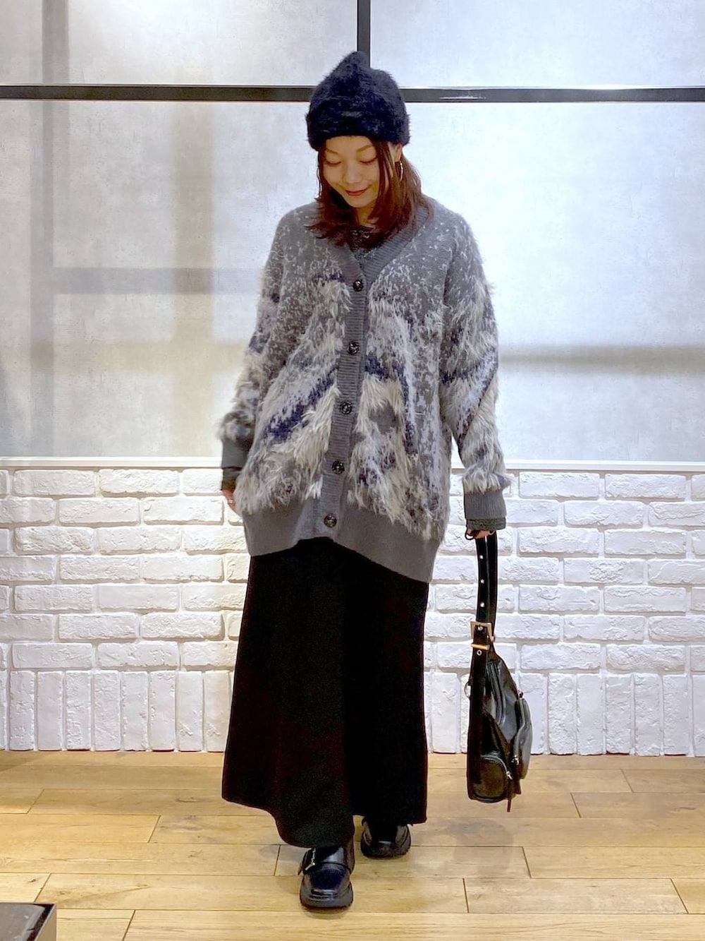 シルバー系のTシャツ/カットソー、ブラック系のブーツ、ブラック系のスカートを着用したレディースの冬コーディネートの4枚目の写真