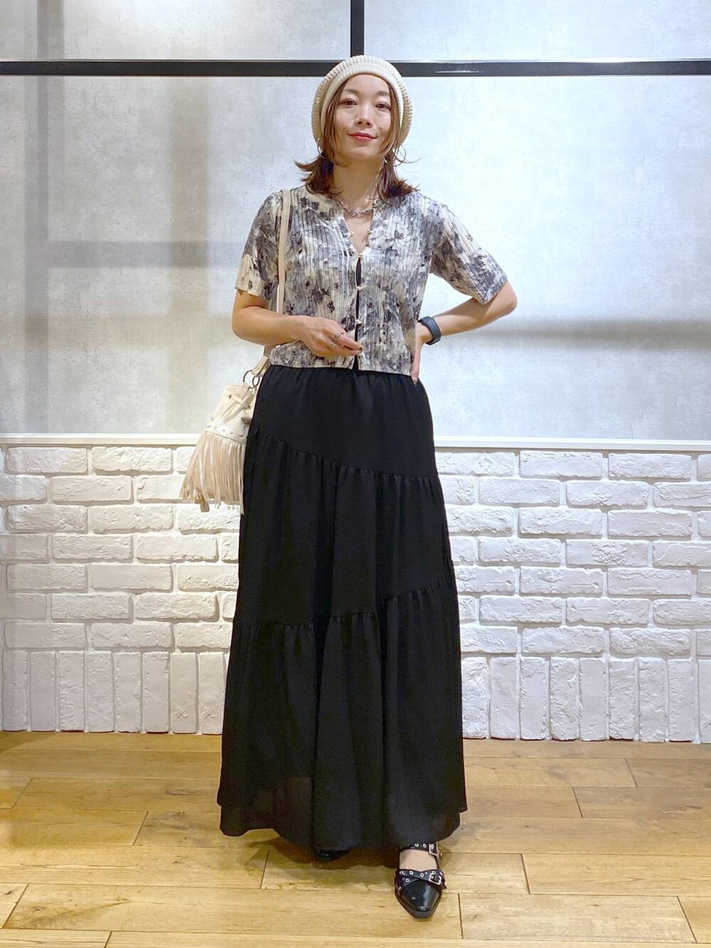 ブラック系のパンプス、ブラック系のスカート、ホワイト系のショルダーバッグを着用したレディースの夏コーディネートの8枚目の写真