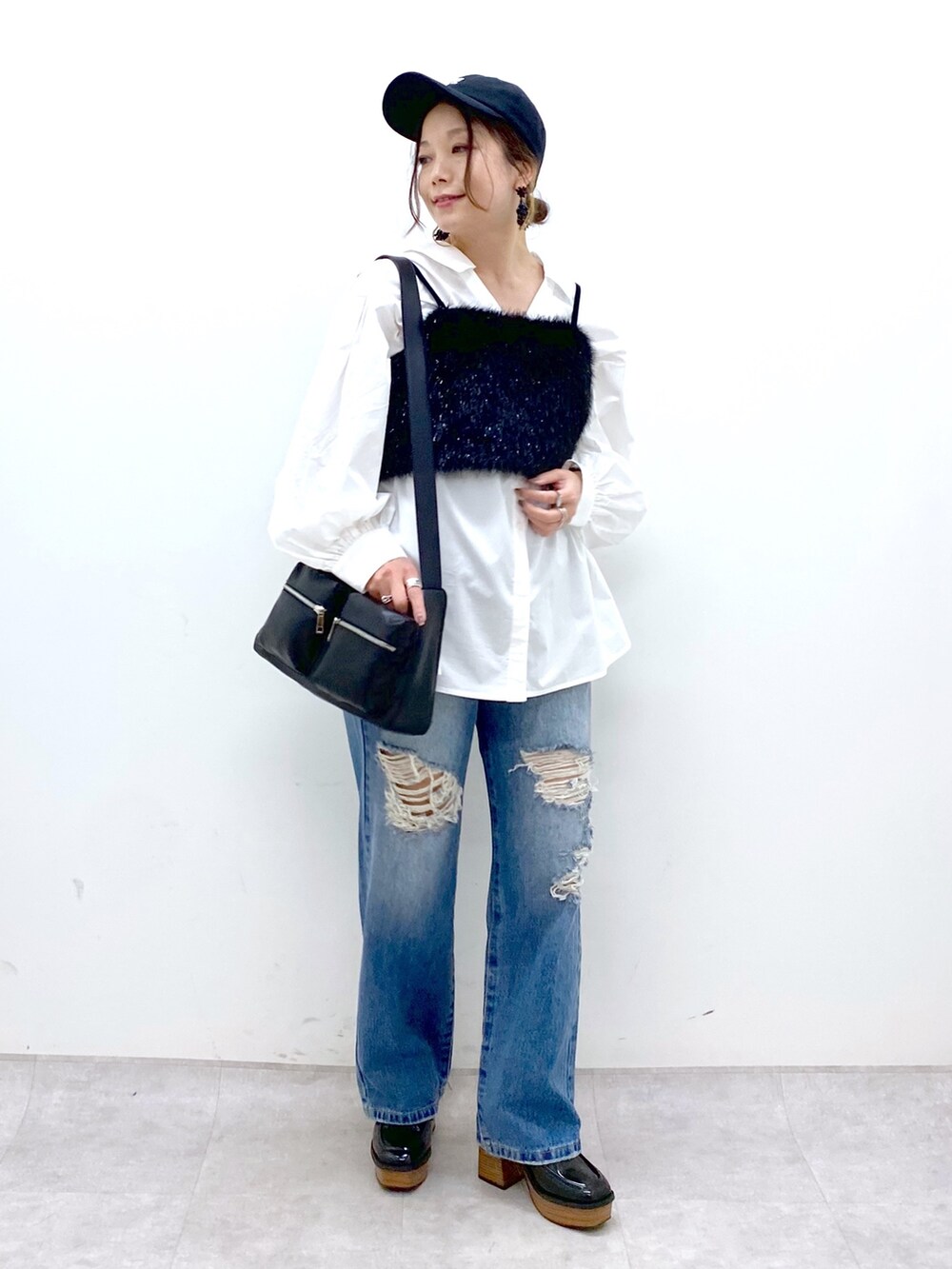 ブルー系のデニムパンツ、ホワイト系のシャツ/ブラウス、ブラック系のベストを着用したレディースの秋コーディネートの9枚目の写真