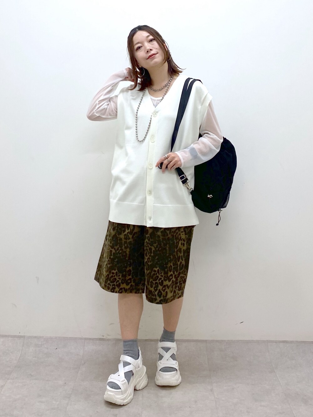 ホワイト系のカーディガン/ボレロ、ホワイト系のTシャツ/カットソー、ブラック系のバックパック/リュックを着用したレディースの春コーディネートの4枚目の写真