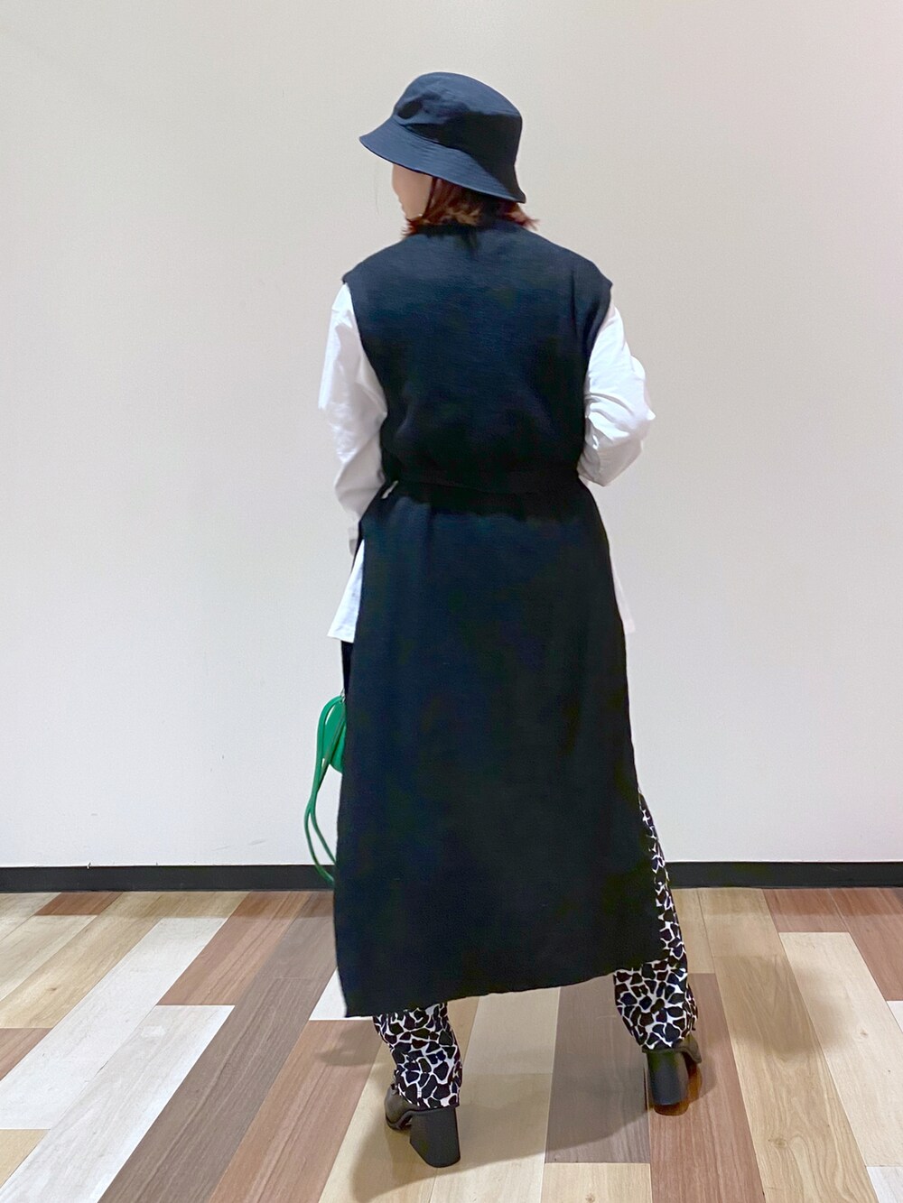 ブラック系のパンプス、ブラック系のワンピース、ホワイト系のTシャツ/カットソーを着用したレディースの冬コーディネートの4枚目の写真