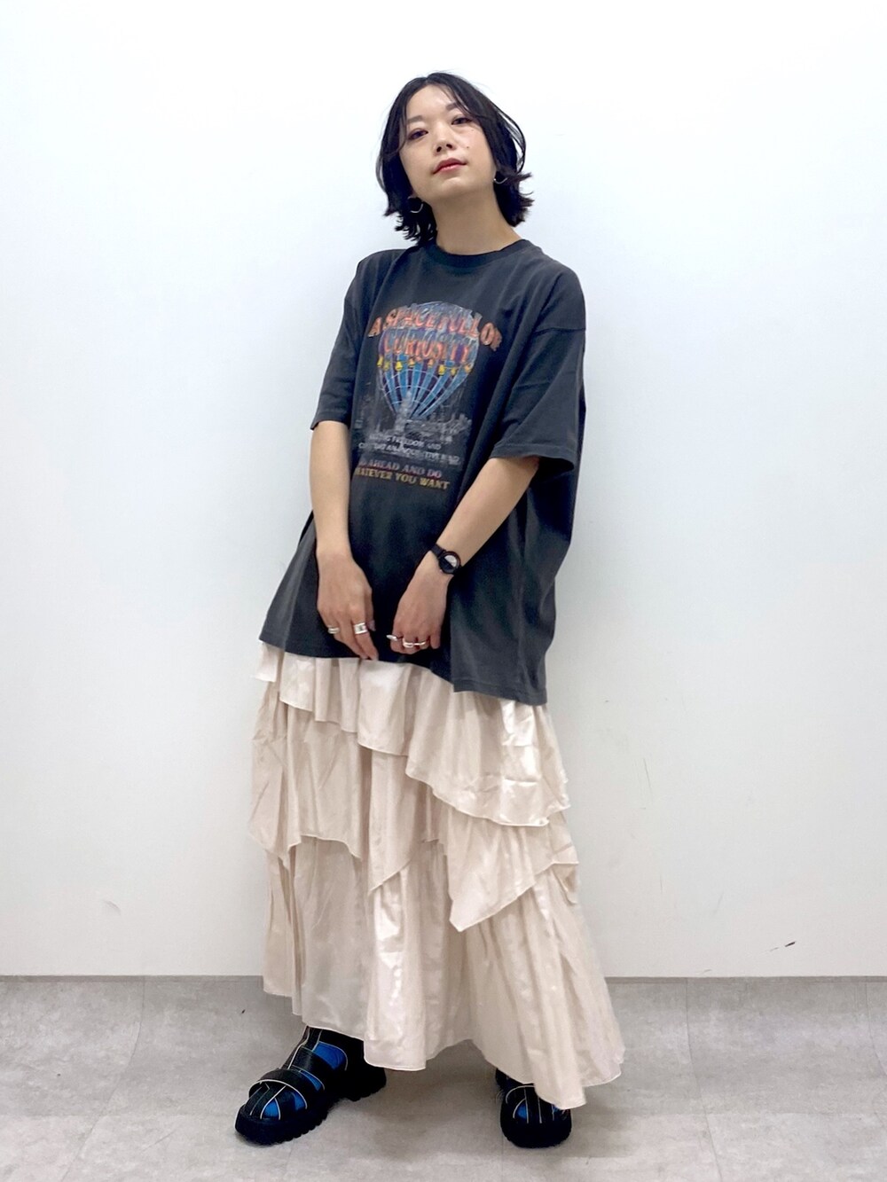 グレー系のTシャツ/カットソー、ホワイト系のスカート、ブラック系のサンダルを着用したレディースの春コーディネートの5枚目の写真