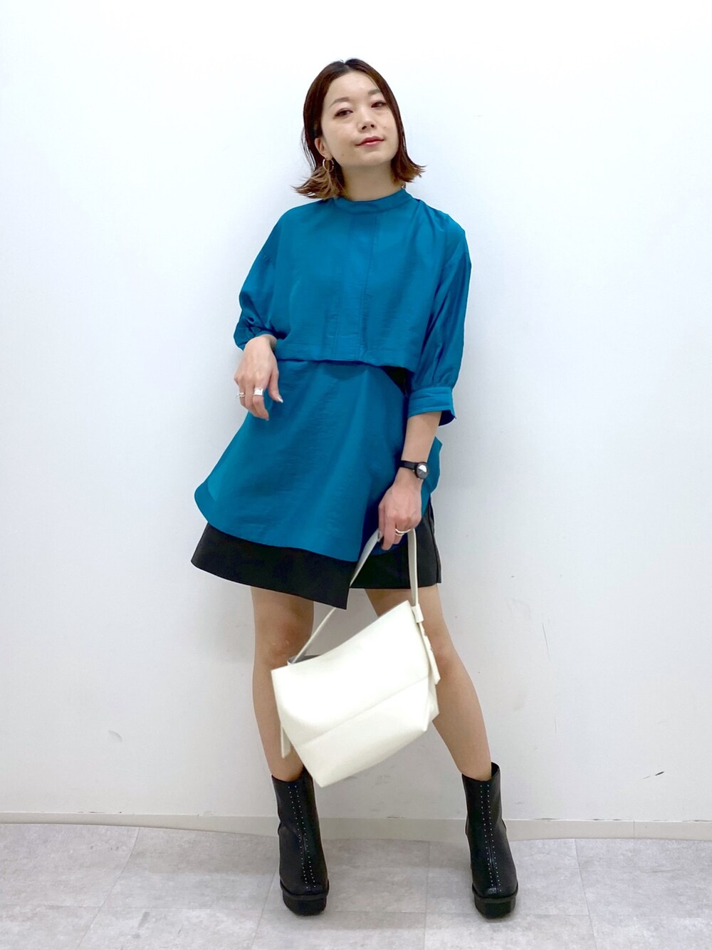 ブルー系のシャツ/ブラウス、ブラック系のパンツ、ホワイト系のバッグを着用したレディースの夏コーディネートの5枚目の写真