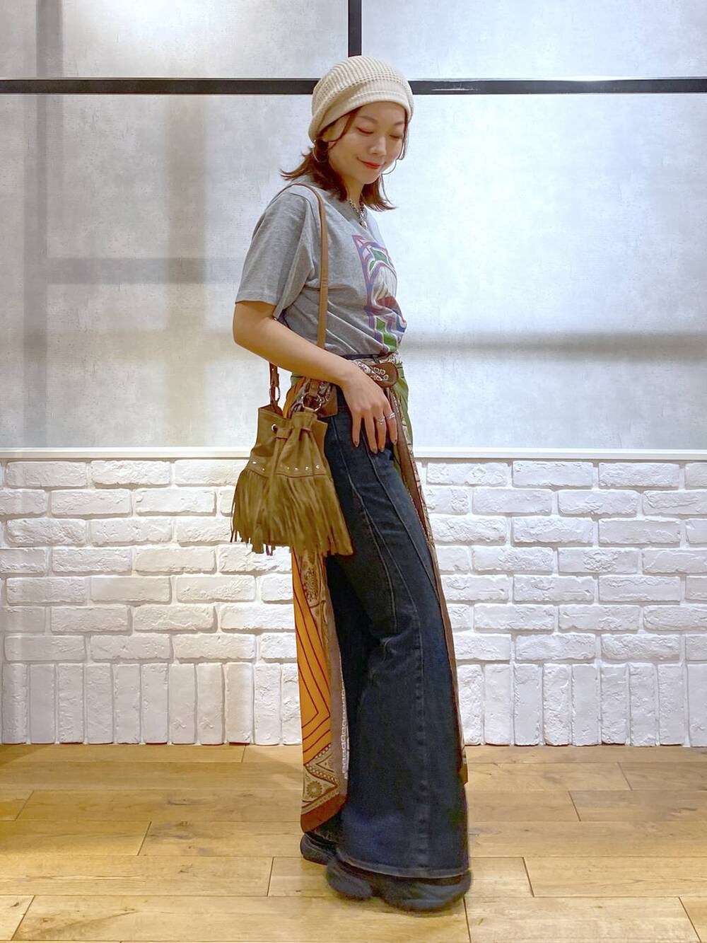 ブラック系のサンダル、ブルー系のデニムパンツ、ベージュ系のショルダーバッグを着用したレディースの夏コーディネートの6枚目の写真