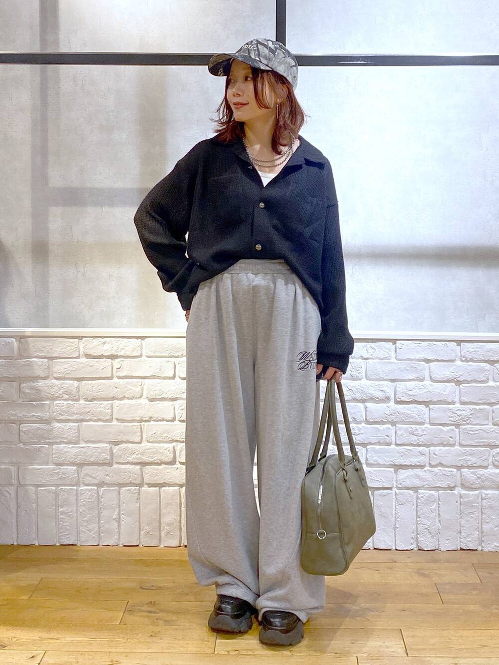 ブラック系のスニーカー、グリーン系のボストンバッグ、グレー系のスウェットパンツを着用したレディースの秋コーディネートの9枚目の写真