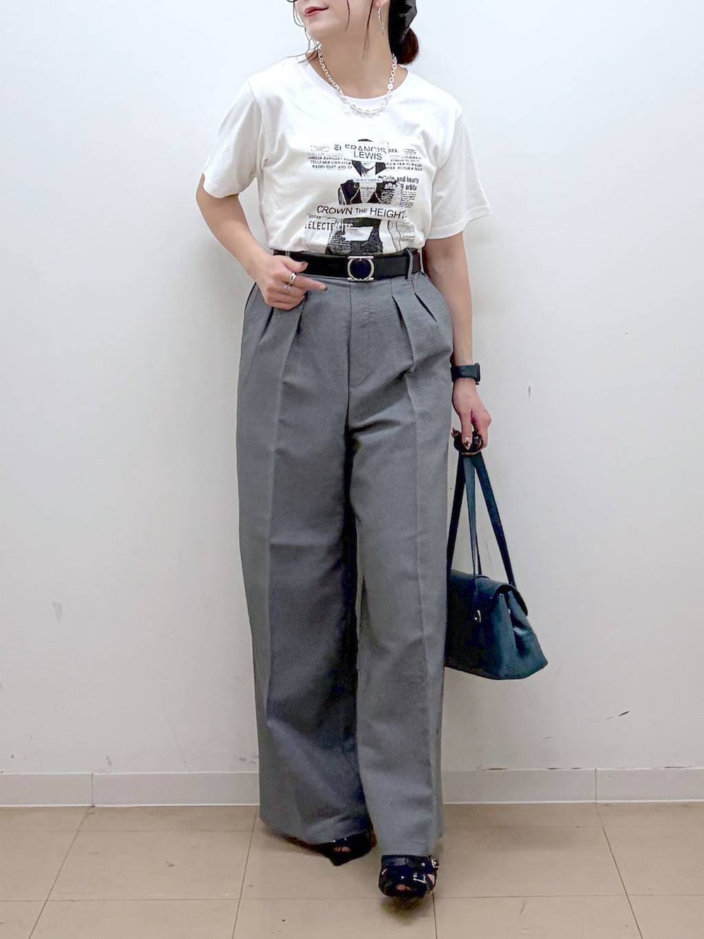 ホワイト系のTシャツ/カットソー、グレー系のスラックス、ブラック系のサンダルを着用したレディースの夏コーディネートの3枚目の写真