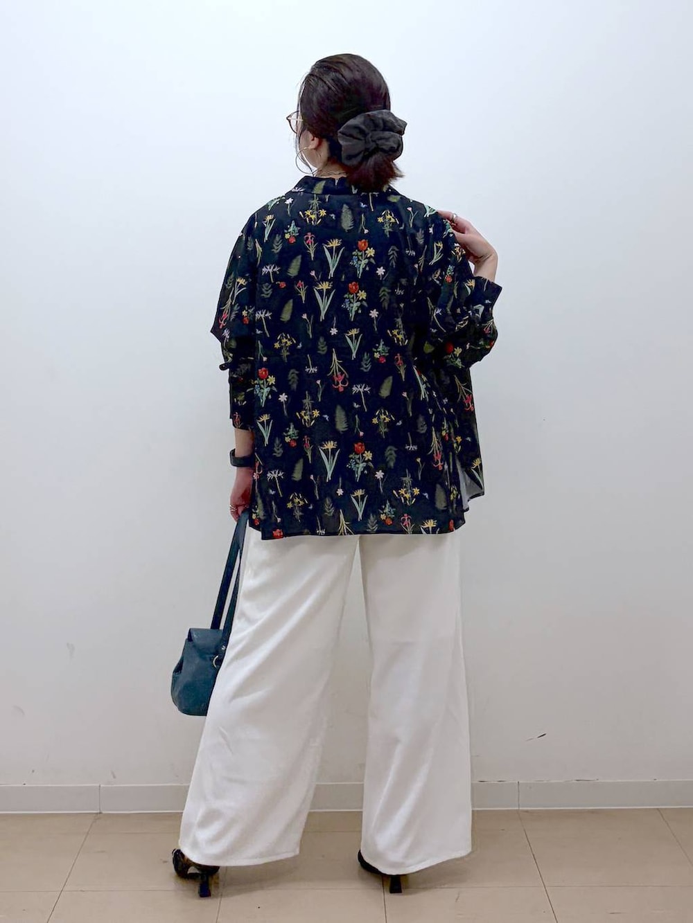 ホワイト系のスラックス、ブラック系のサンダル、グレー系のTシャツ/カットソーを着用したレディースの夏コーディネートの6枚目の写真