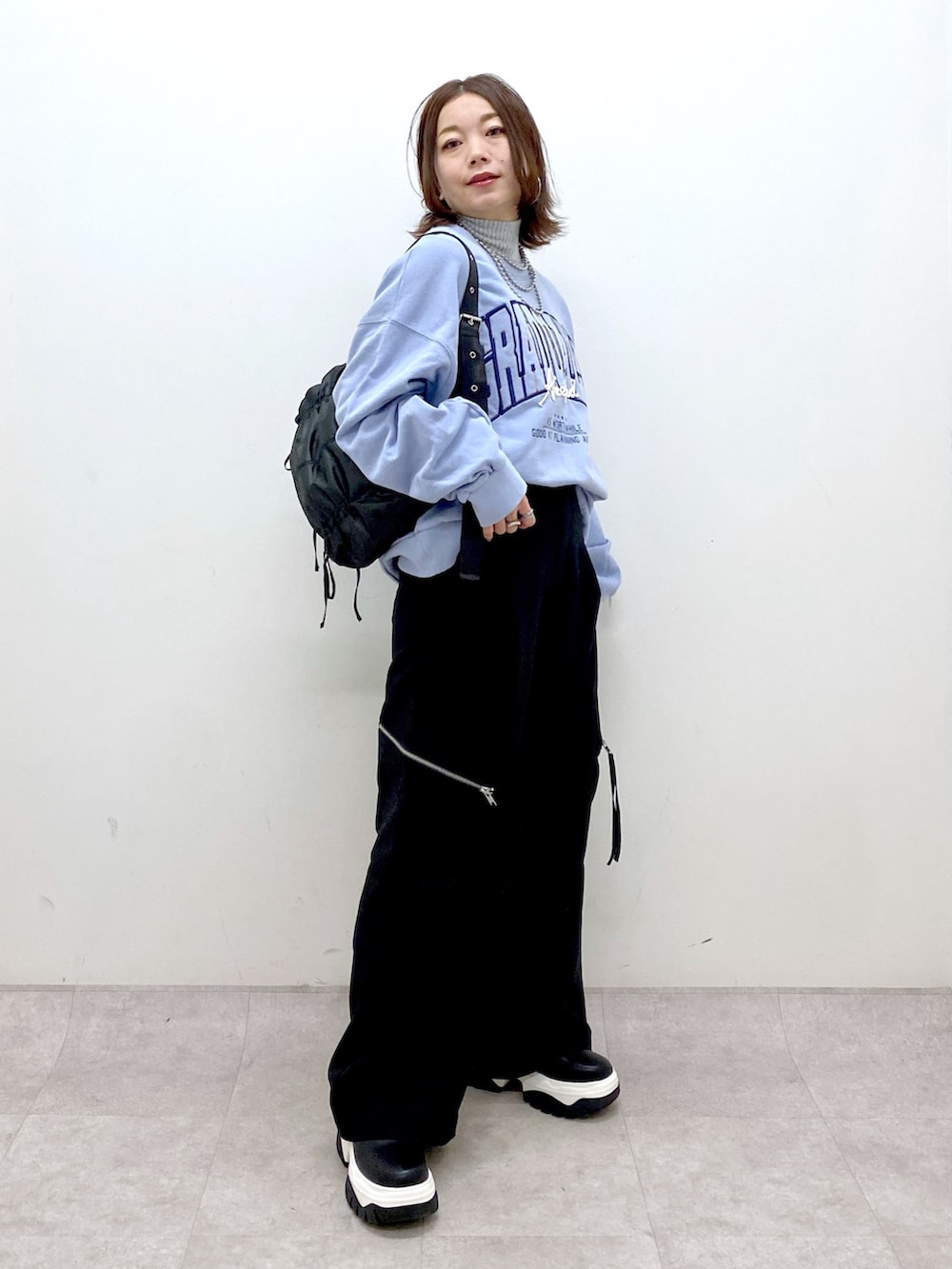 ブルー系のスウェット、ブラック系のカーゴパンツ、ブラック系のブーツを着用したレディースの冬コーディネートの8枚目の写真