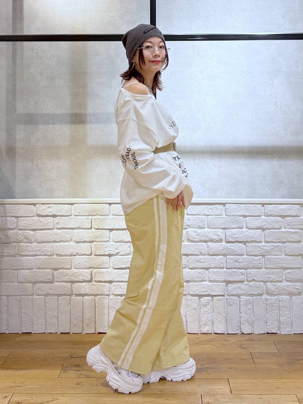 ホワイト系のスニーカー、イエロー系のスウェットパンツ、ホワイト系のTシャツ/カットソーを着用したレディースの春コーディネートの7枚目の写真