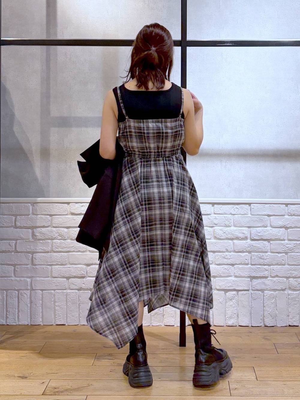 ブラック系のブーツ、ブラック系のハンドバッグ、ブラック系のテーラードジャケットを着用したレディースの春コーディネートの5枚目の写真