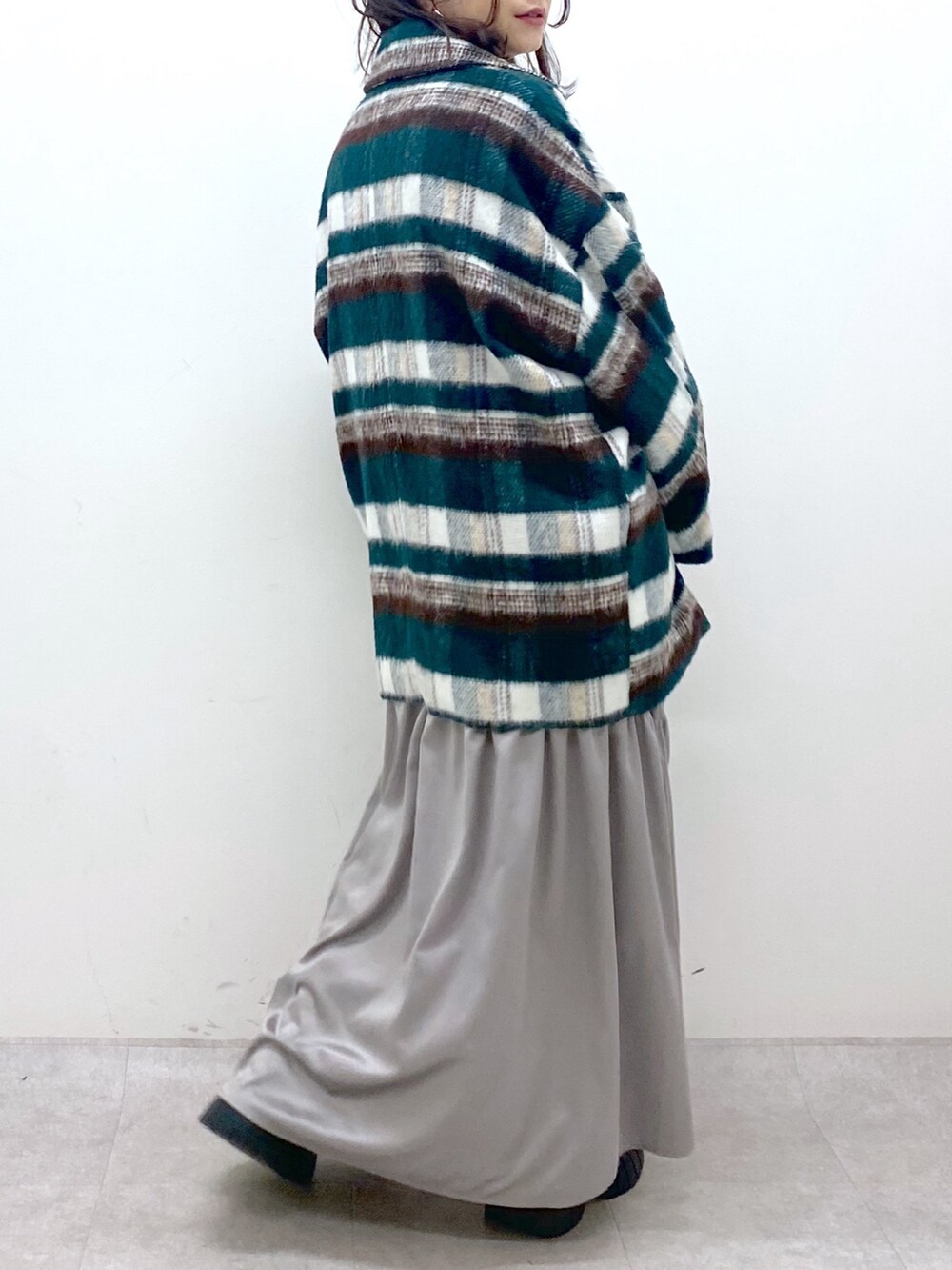 グリーン系のその他アウター、ホワイト系のニット/セーター、ホワイト系のワンピースを着用したレディースの冬コーディネートの8枚目の写真