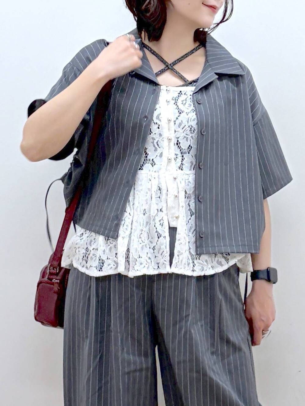 レッド系のショルダーバッグ、ブラック系のサンダル、グレー系のタンクトップを着用したレディースの夏コーディネートの2枚目の写真