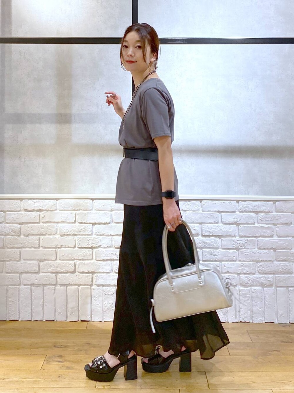ブラック系のブーツ、シルバー系のショルダーバッグ、グレー系のTシャツ/カットソーを着用したレディースの夏コーディネートの5枚目の写真