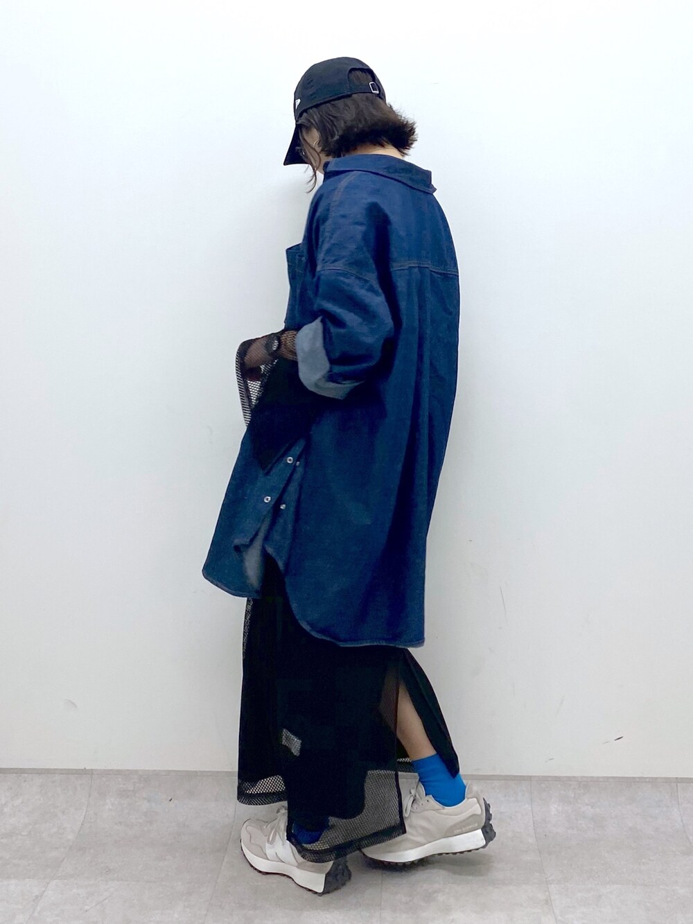 ブルー系のトップス、ブラック系のワンピース/ドレス、ベージュ系のスニーカーを着用したレディースの春コーディネートの4枚目の写真