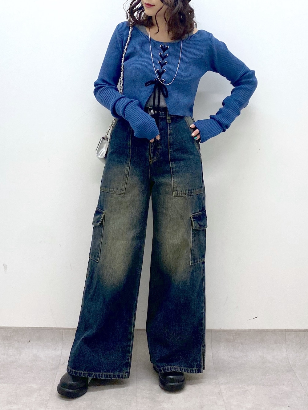 ブルー系のデニムパンツ、ブルー系のニット/セーター、ブラック系のブーツを着用したレディースの冬コーディネートの6枚目の写真