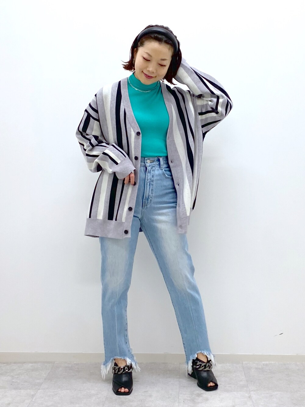 グリーン系のTシャツ/カットソー、ブルー系のデニムパンツ、ブラック系のパンプスを着用したレディースの冬コーディネートの2枚目の写真