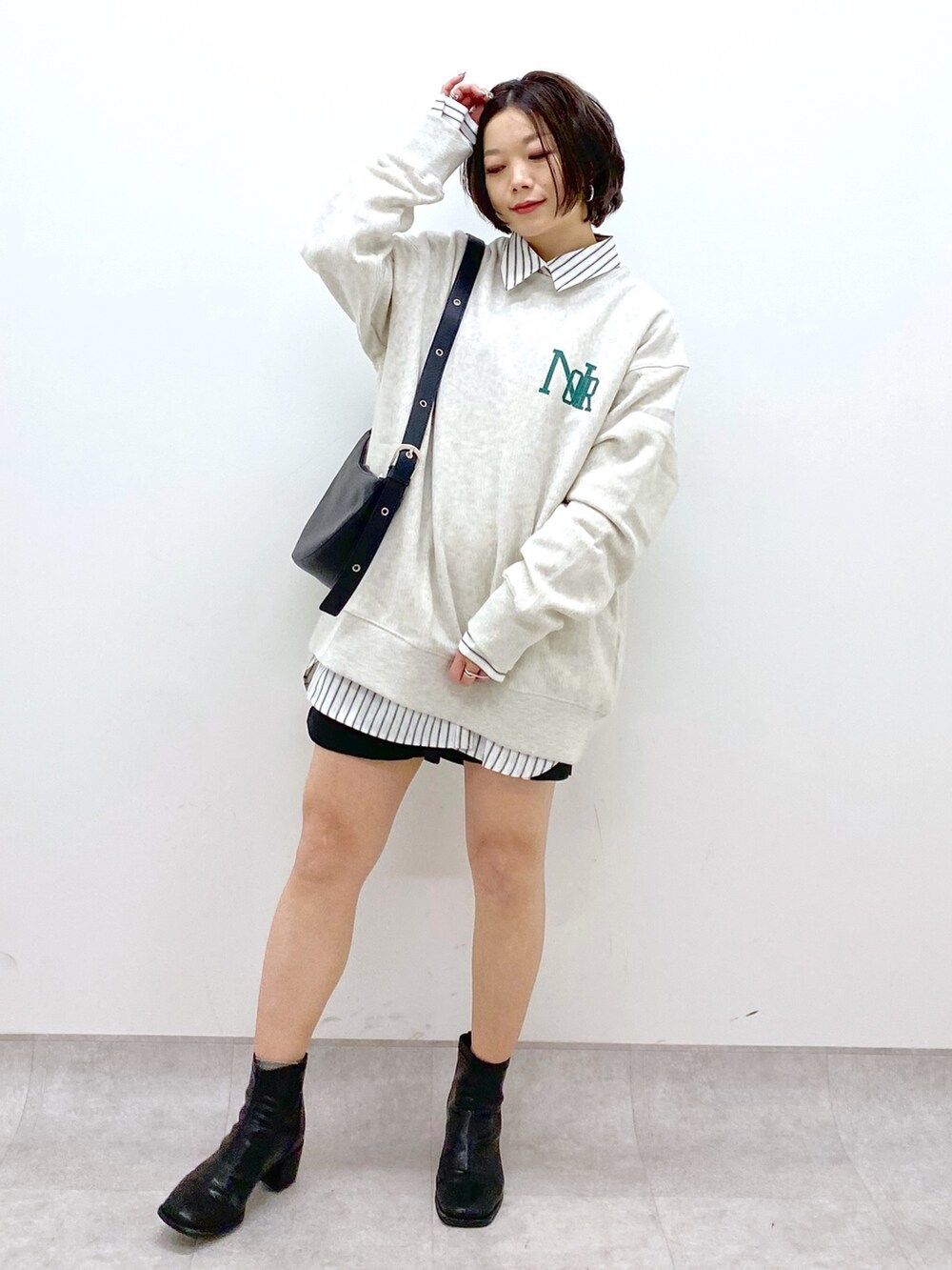 ブラック系のショルダーバッグ、ブラック系のシューズ、ベージュ系のトップスを着用したレディースの冬コーディネートの5枚目の写真