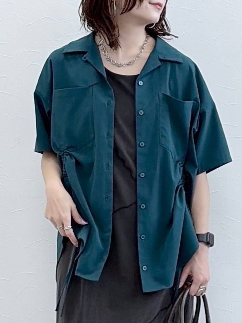 ブラック系のワンピース、グレー系のショルダーバッグ、グリーン系のシャツ/ブラウスを着用したレディースの春コーディネートの2枚目の写真