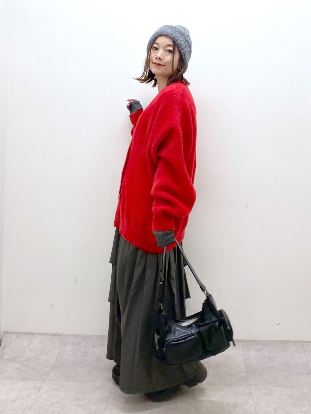 レッド系のカーディガン/ボレロ、シルバー系のTシャツ/カットソー、ブラウン系のスカートを着用したレディースの秋コーディネートの7枚目の写真