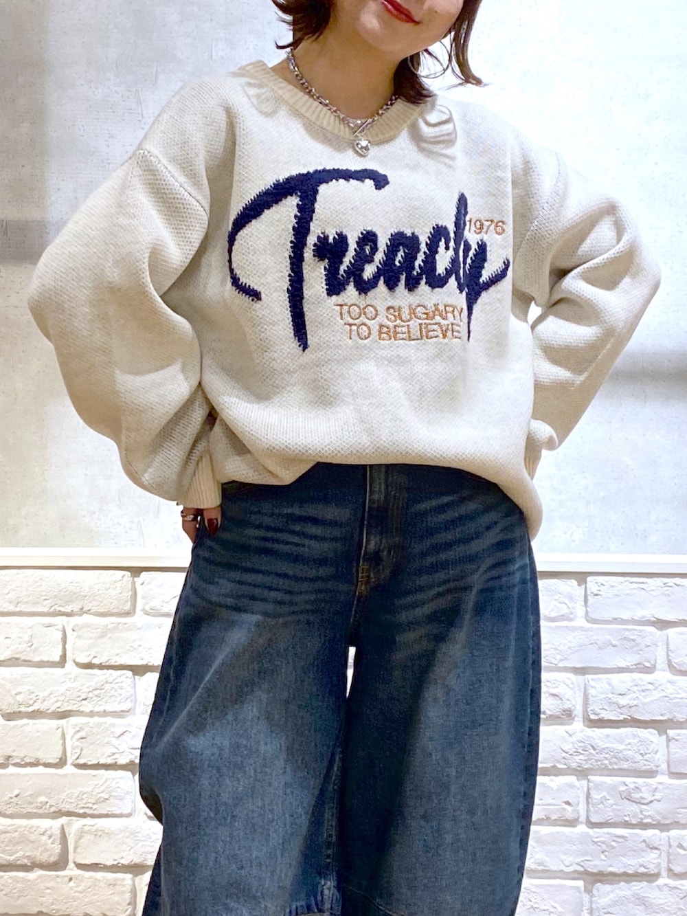 ホワイト系のニット/セーター、ブルー系のデニムパンツ、ブラウン系のブーツを着用したレディースの冬コーディネートの2枚目の写真