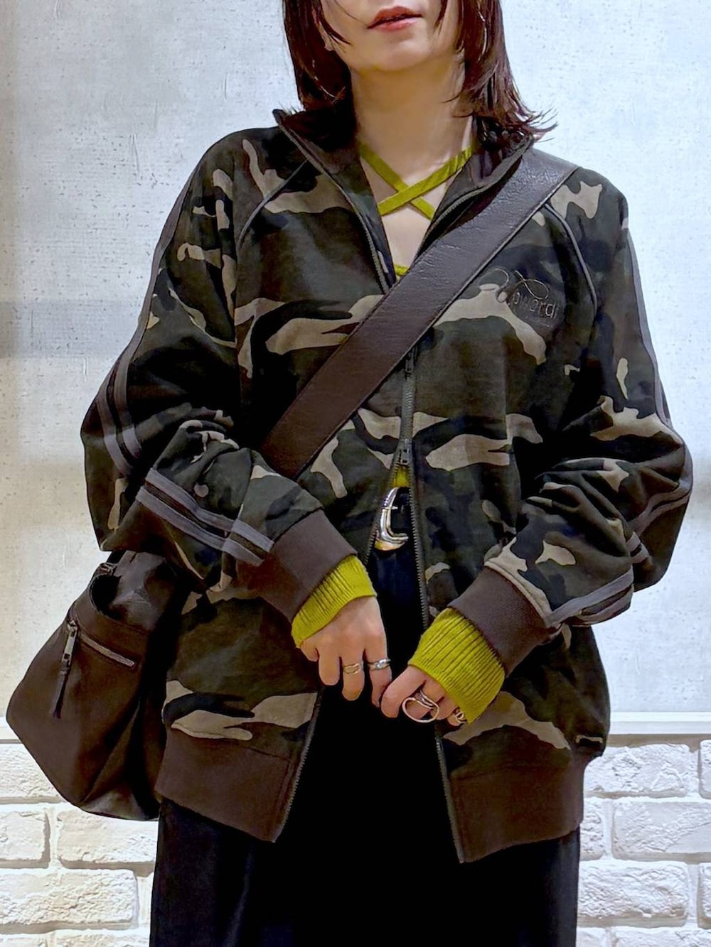 グレー系のスニーカー、ブラウン系のボストンバッグ、イエロー系のニット/セーターを着用したレディースの冬コーディネートの2枚目の写真