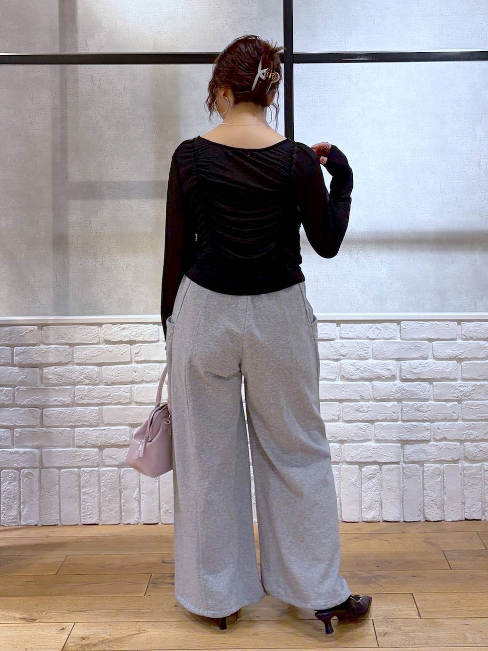 ホワイト系のキャミソール、ピンク系のハンドバッグ、グレー系のスウェットパンツを着用したレディースの春コーディネートの6枚目の写真