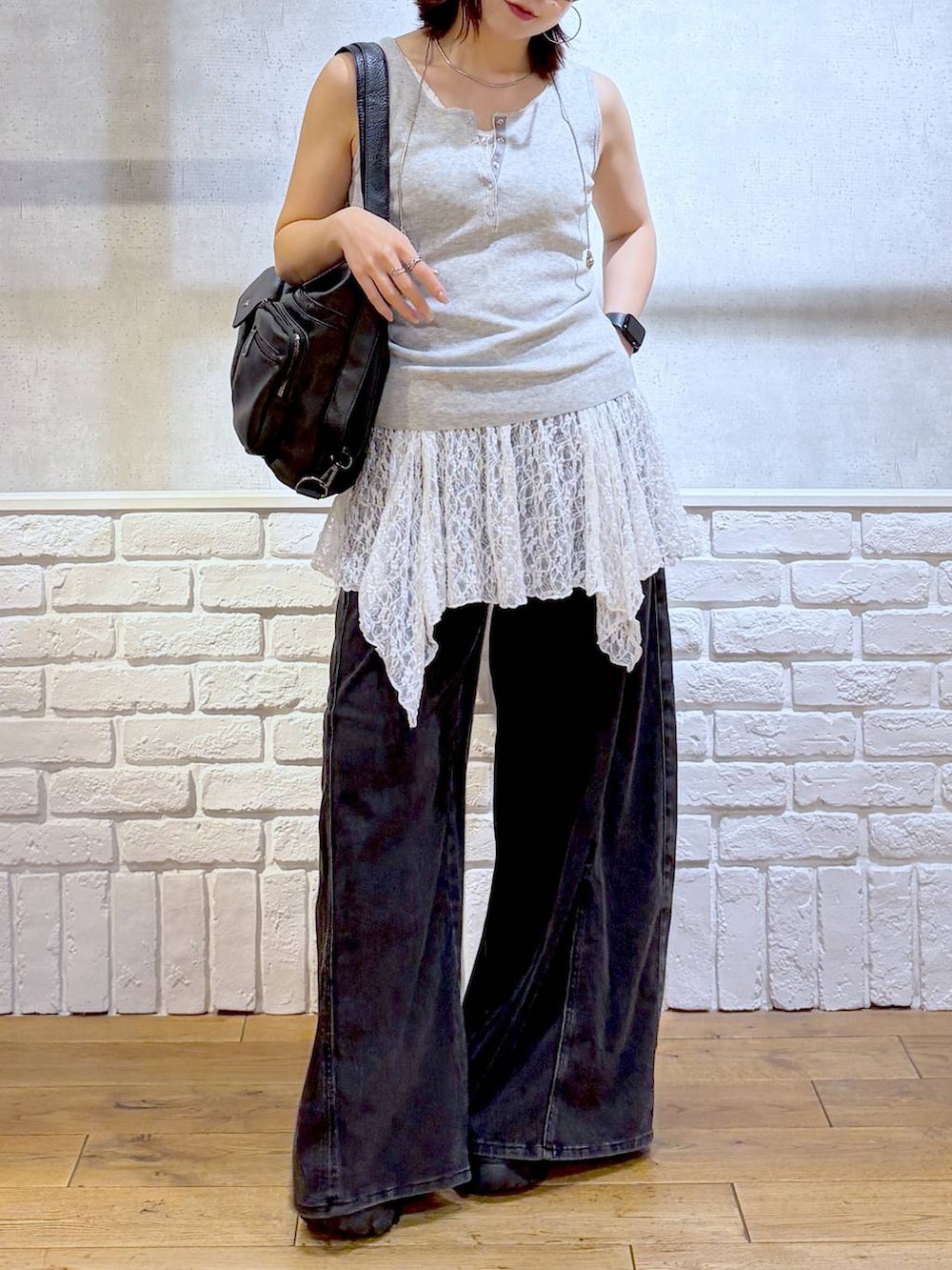 ブラック系のデニムパンツ、ブラック系のショルダーバッグ、ブラック系のサンダルを着用したレディースの夏コーディネートの3枚目の写真